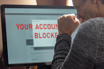 Poster - Man with financial problems trying to make online payment. Man frustrated, staring at monitor with account freeze, payment block, and card lock alert