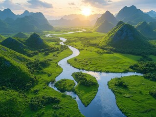 Poster - Lush Green Landscape Featuring Winding River Through Mountainous Terrain at Sunrise with Golden Sunlight Illuminating Scenic Views