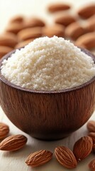 Poster - Almond flour in wooden bowl with almonds on light surface close up view healthy food concept
