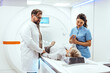 © Dragana Gordic - Doctors and Nurse Assisting Patient During Advanced MRI Scan in Modern Hospital