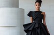 © Milos - A striking image of a model wearing an elegant black dress featuring dynamic ruffles, set against a contemporary architecture backdrop that highlights the fashion.
