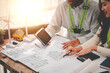 © Suphakant - Engineers work as a team with blueprints for architectural plans. Engineer sketching construction project concept with architect equipment Architects talking at table Teamwork and construction concept