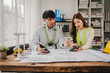 © Suphakant - Engineers work as a team with blueprints for architectural plans. Engineer sketching construction project concept with architect equipment Architects talking at table Teamwork and construction concept