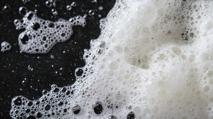 Poster - Close-Up of White Soap Bubbles on Dark Surface Creating a Dynamic Textured Background with Organic Patterns and Shadow Effects for Visual Appeal