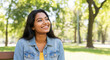 © Postmodern Studio - Young asian female smiling in park with sunlit background