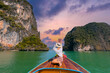 Travel Woman enjoying scenic sunset from wooden boat in phang nga bay, Thailand