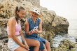 © milanmarkovic78 - Mother And Daughter Using Phone By The Beach