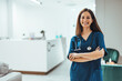 © Dragana Gordic - Smiling Female Nurse in Uniform Standing Confidently in a Modern Office Setting