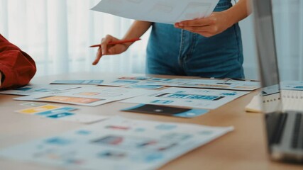 Fototapete - Excellent startup company employee presenting user interface prototype for mobile application to smart co-worker in office workspace. UX UI designer explain function of icon design on paper. Synergic