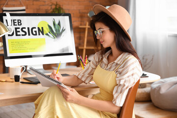 Fototapete - Female interior designer working at table in office
