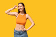 © Pixel-Shot - Beautiful young happy woman with piercing navel showing victory gesture on yellow background