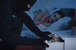 © Prostock-studio - Robber stealing money from drawer in the night, breaking in house with peaceful female tenant sleeping in the background