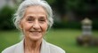 © CreativeMinds - Happy old woman with white hair close-up portrait at a zen garden background, healthy aging, gratefulness concept