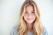 © He - woman with long blonde hair smiles at the camera