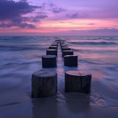Poster - Serene Seascape with Wooden Poles Leading Towards a Colorful Sunset Over Calm Waters and Dramatic Cloud Formation in the Evening Sky