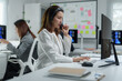 © Phimwilai - Asian businesswoman wearing headset is working as customer service operator talking with client on computer in office