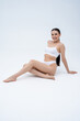 © zinkevych - Pretty young caucasian young woman sitting on the floor on a white background