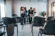 © standret - Standing by the laptop. Group of young business people are in conference room