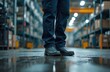 © Vadym - Worker stands in safety boots in industrial environment on wet floor. Protective footwear workwear for occupational safety heavy duty footwear at manufacturing labor factory. Blue collar workplace