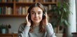 © Vadym - Smiling woman with headphones in video call. Brunette female talking online in conference. Pretty girl with hand on headset enjoys audio listening. Remote studying, e-learning and telecommunication.