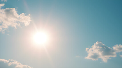 bright sun shining in a clear blue sky with scattered clouds, conveying warmth, clarity, and a sense