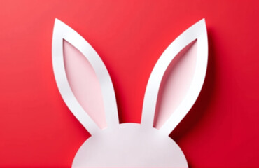 Poster - White Paper Cut Bunny Ears Are Isolated Against A Bright Red Background In This Easter Greeting Card Design.