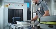 © Framestock - Airport Security Checkpoint: Security Officer Putting Suitcases and Personal Items in Trays on Conveyor Belt with X-ray Scanning. People Passing Through Metal Detector Gates. TSA Screening Procedures.
