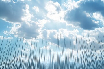 Wall Mural - low angle view of numerous tall, slender poles against a bright, partly cloudy sky.