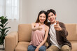 © Chanakon - Happy moment of asian family man and woman husband and wife just married buying new house. Relax on sofa in living room