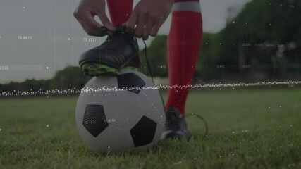 Poster - Soccer player tying shoe over digital data animation on grassy field