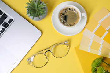 Aufkleber - Designer's workplace with laptop, stationery and cup of coffee on yellow background, flat lay
