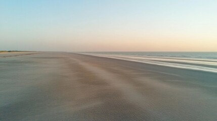 Fototapete - Breathtaking sunset over an empty beach with a vast stretch of sand and tranquil waters at the horizon Generative AI