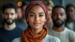 © mlangsen - Smiling woman in headscarf leads diverse group; office backdrop