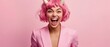 © Fernando - Excited Caucasian woman with pink hair and devil horns screaming in a pink suit Concept of Halloween, party, and costume