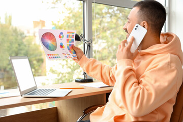 Fototapete - Graphic designer working with laptop and color palette at home