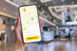 © vadish - Woman using taxi app on smartphone, ordering taxi in shopping mall.