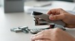 © Artyom - Close-up of hands using stapler on desk with staples