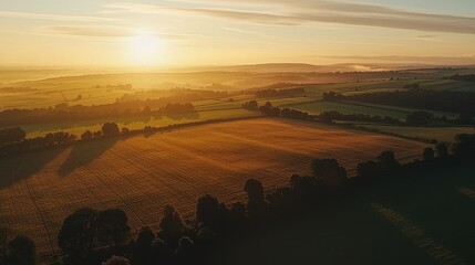 Poster - A vast countryside landscape glowing under a radiant sunset, with fields stretching to the horizon.