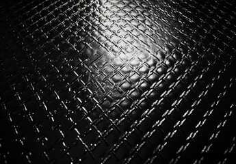Poster - Dark Textured Surface with Diamond Pattern in Glossy Finish Under Soft Light Highlighting Depth and Detail for Industrial Design and Backdrop Use