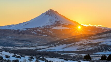 Poster - A mountain peak glowing under the golden hues of sunset, surrounded by a snow-covered landscape.