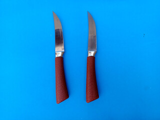 pair of knives with brown handles on blue background