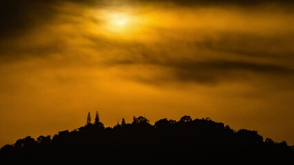 Wall Mural - dramatic sunset time lapse over a cloudy mountain ridge.