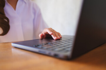 Wall Mural - closeup image of a woman working and touching on laptop computer touchpad