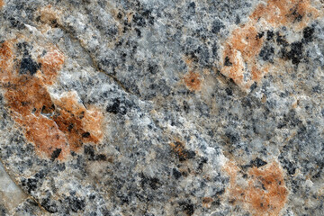 Poster - Close-up view of a rough, textured stone surface with gray, black, and orange hues.
