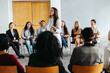 © Jacob Lund - Business event with diverse group learning in workshop setting led by energetic speaker