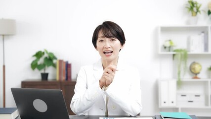 Leinwandbilder - カメラ目線で会話する白衣のミドル女性