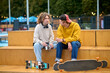 © zinkevych - Young couple of skateboarders sitting on the bench and talking