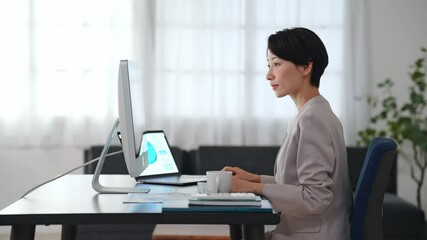Leinwandbilder - 暗いオフィスでパソコンを使って作業する女性ビジネスパーソン