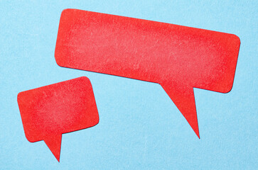 Poster - Red blank cut out paper speech bubbles with copy space for text on blue background, flat lay top view conceptual conversation backdrop