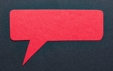 Poster - Red cut out blank paper speech bubble of rectangular shape and rounded corners with copy space for text on dark background, flat lay top view conceptual backdrop